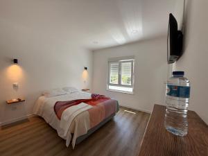 a bedroom with a bed and a bottle of water at 5Melros in Santiago do Cacém