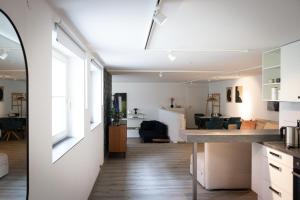 a kitchen and living room with white walls and wooden floors at Retro-Urban in der Bregenzer Fussgängerzone in Bregenz