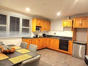 a kitchen with wooden cabinets and a table with chairs at Richmond Villa in Invercargill