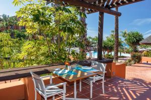 a table and chairs on a patio with a view of the ocean at Royal Hideaway Sancti Petri in Chiclana de la Frontera