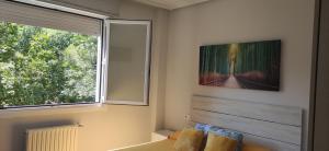 1 dormitorio con ventana grande y espejo en Spacious with free parking in Old Town-Casco Viejo, en Bilbao