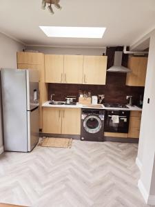 a kitchen with a refrigerator and a washing machine at Alross Guest House in London