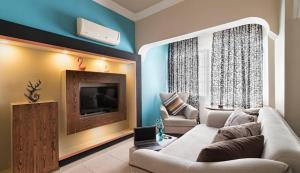 a living room with a couch and a tv at Loft Suit Apart Otel in İskenderun