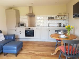 a kitchen with a table and a blue couch at Acorn Cottage in Boston