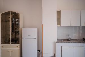 a white kitchen with a refrigerator and a sink at Residence Riviera in Palinuro +87 photos