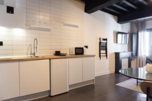 a kitchen with white cabinets and a table at La Antigua Fonda Relator in Hervás +41 photos