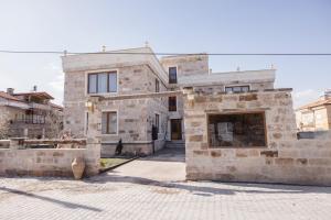 a stone house with a courtyard in front of it at Zeppelin Cappadocia in Uçhisar