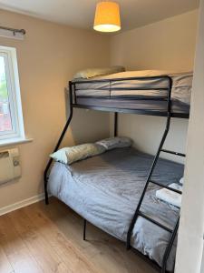 a room with two bunk beds and a window at Modern, Quiet, Sleeps 9, Etihad, CoOp Live, Manchester in Manchester