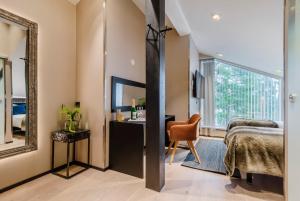 a bedroom with a bed and a mirror at Boutique-hotelli Vellamo - Lehmonkärki Resort in Asikkala