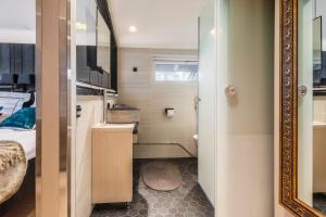 a small bathroom with a bed and a mirror at Boutique-hotelli Vellamo - Lehmonkärki Resort in Asikkala