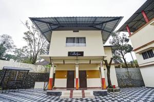 a building with a sign that reads malachi at Hotel O Valley View Residency in Vagamon