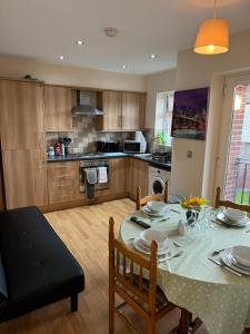 a kitchen with a table and a dining room at Modern, Quiet, Sleeps 9, Etihad, CoOp Live, Manchester in Manchester