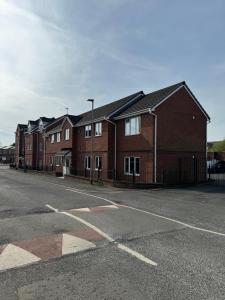 a row of brick houses on the side of a street at Modern, Quiet, Sleeps 9, Etihad, CoOp Live, Manchester in Manchester