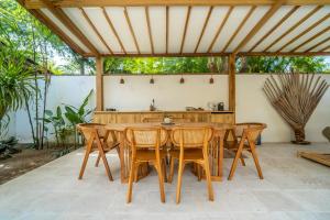 an outdoor kitchen with a wooden table and chairs at Villa Maiya - Charming 1-Bedroom Villa with Pool in Gili Islands