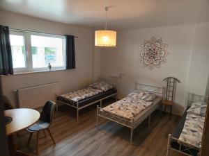 ein Zimmer mit zwei Betten und einem Tisch und einem Fenster in der Unterkunft 1-ZApp "TRENDHAUS-1" Zentrum! in Hofgeismar
