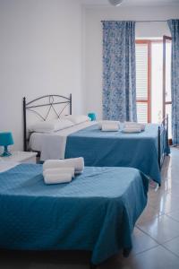 two beds in a room with blue and white at Residence Riviera in Palinuro
