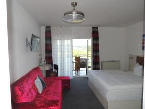um quarto de hotel com uma cama e um sofá vermelho em Gasthof Kessler em Oberthulba