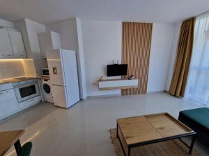 a living room with a kitchen and a living room with a table at Апартамент БАНГЕВИ in Burgas +7 photos