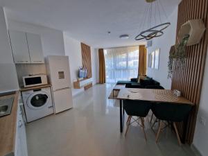a kitchen and living room with a table and chairs at Апартамент БАНГЕВИ in Burgas