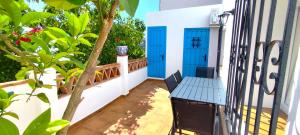 a balcony with a blue door and a table at El Carmen de Sexi in Almuñécar