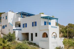 a house on a hill with white walls and blue windows at Cozy Betelgeuse in Agkidia