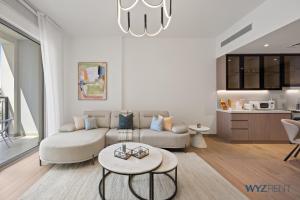 una sala de estar con un sofá y una mesa en Boho Bayfront 1BR in La Sirene 2 Seaport View, en Dubái