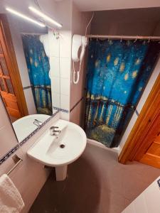 a bathroom with a sink and a shower curtain at Apartamento Bajondillo Cozy Inns in Torremolinos