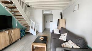 a living room with a couch and a staircase at Coconest - Duplex on the beach in Baie Nettle