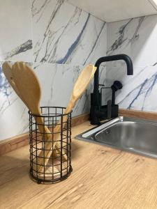zwei hölzerne Küchenutensilien in einem Korb neben einer Spüle in der Unterkunft El Rincón de Elena II in Cazorla + 21 Fotos