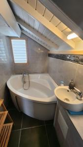 a bathroom with a white tub and a sink at Coconest - Duplex on the beach in Baie Nettle +17 photos