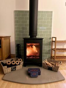 a fireplace with two baskets and a stove at The Stables at The Forge Self Contained Apartment in Pyecombe