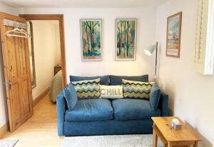 a blue couch sitting in a living room at The Stables at The Forge Self Contained Apartment in Pyecombe