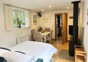 a bedroom with a bed and a room with a stove at The Stables at The Forge Self Contained Apartment in Pyecombe