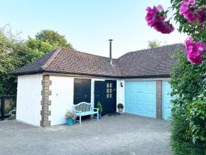 a garage with two blue garage doors and a bench at The Stables at The Forge Self Contained Apartment in Pyecombe