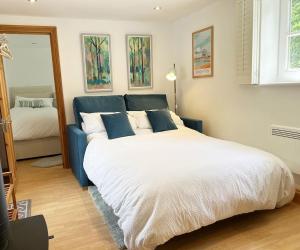 a bedroom with a large white bed with blue pillows at The Stables at The Forge Self Contained Apartment in Pyecombe