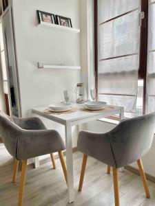 een eettafel met 2 stoelen en een witte tafel bij Deluxe studio beach Lazur in Boergas