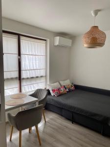 een kleine kamer met een bed, een tafel en een bank bij Deluxe studio beach Lazur in Boergas