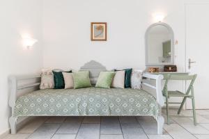a room with a bench with pillows and a table at Birbas Hotel in Agia Anna Naxos