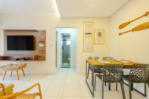 uma sala de jantar e sala de estar com mesa e cadeiras em Apartamento Praia Enseada - Guarujá no Guarujá