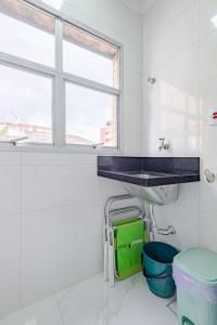 um banheiro com uma pia, um vaso sanitário e uma janela em Apartamento Praia Enseada - Guarujá no Guarujá mais 44 fotografias