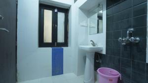 un bagno con lavandino, water e finestra di hotel kishangarh jaisalmer a Jaisalmer