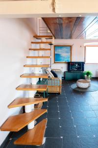 salon z drewnianymi schodami i łóżkiem w obiekcie Delizioso Loft a Forte Stella, Isola d'Elba w mieście Portoferraio