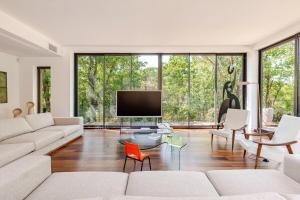 Una sala de estar con un sofá y un televisor de pantalla plana. en Villa Bim, en Bonnieux