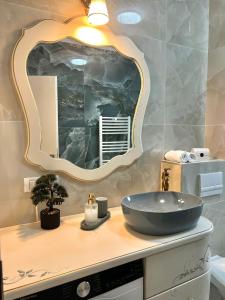 ein Badezimmer mit Waschbecken und großem Spiegel in der Unterkunft Bridge Apartments- STUDIO 7 in Besenic