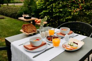a table topped with plates of food and orange juice at Boutique B&B Oud Aa in Breukelen
