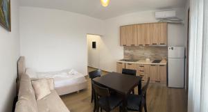 a living room with a couch and a table and a kitchen at Vila Martini in Vlorë