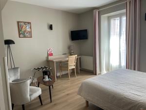 a bedroom with a bed and a table and chairs at Hotel Kapa Gorry in Saint-Jean-de-Luz