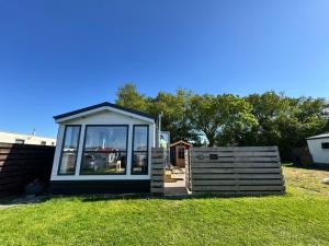 a small gazebo in a yard with a fence at PRACHTiG CHALET ZONNESTRAAL in Westerland +16 photos