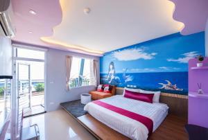 a bedroom with a large bed and a blue wall at Hold 住 208 好住民宿 in Xiaoliuqiu