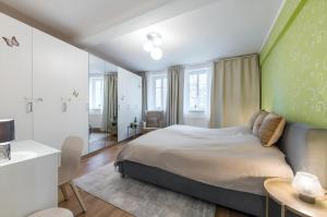 Un dormitorio con una cama con una pared verde. en Promenade View Apartment, en Karlovy Vary